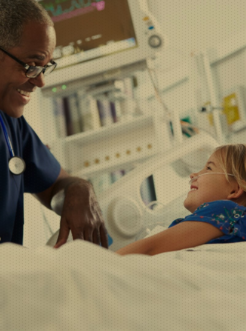 Doctor helping young child in hospital bed