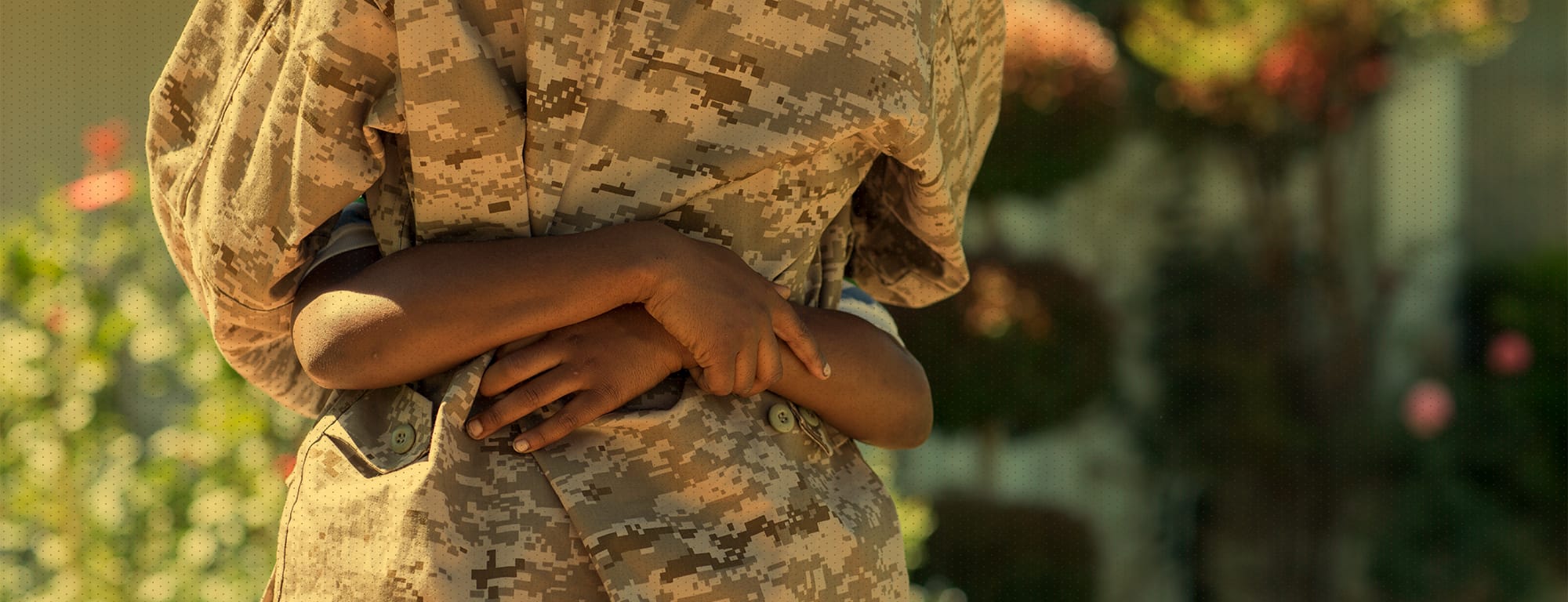 Adult in camouflage hugging child