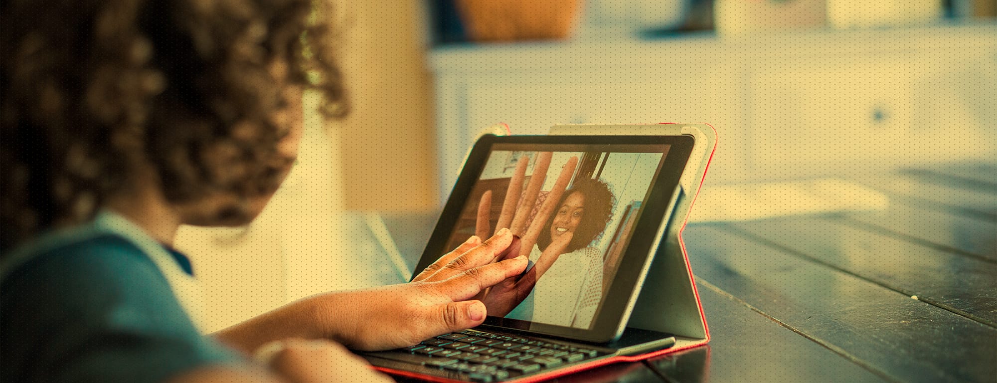 Young girl video chatting with adult on tablet