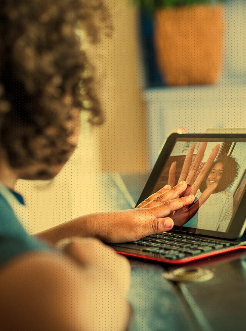 Young girl video chatting with adult on tablet