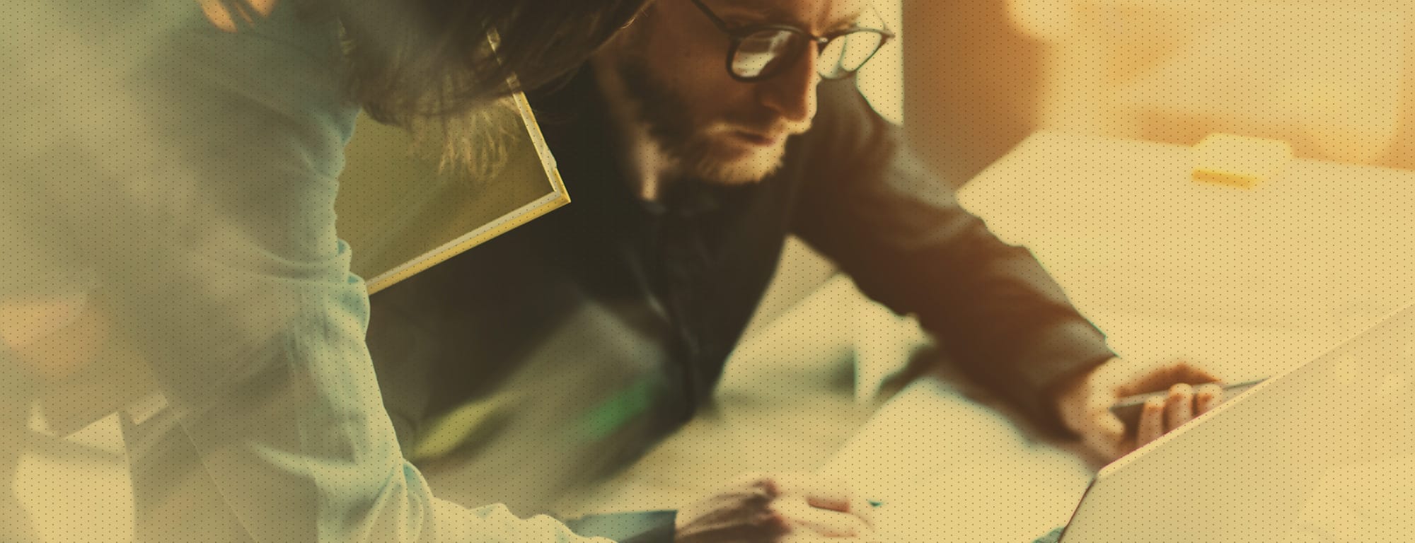 Male looking intently at computer while collaborating with female employee