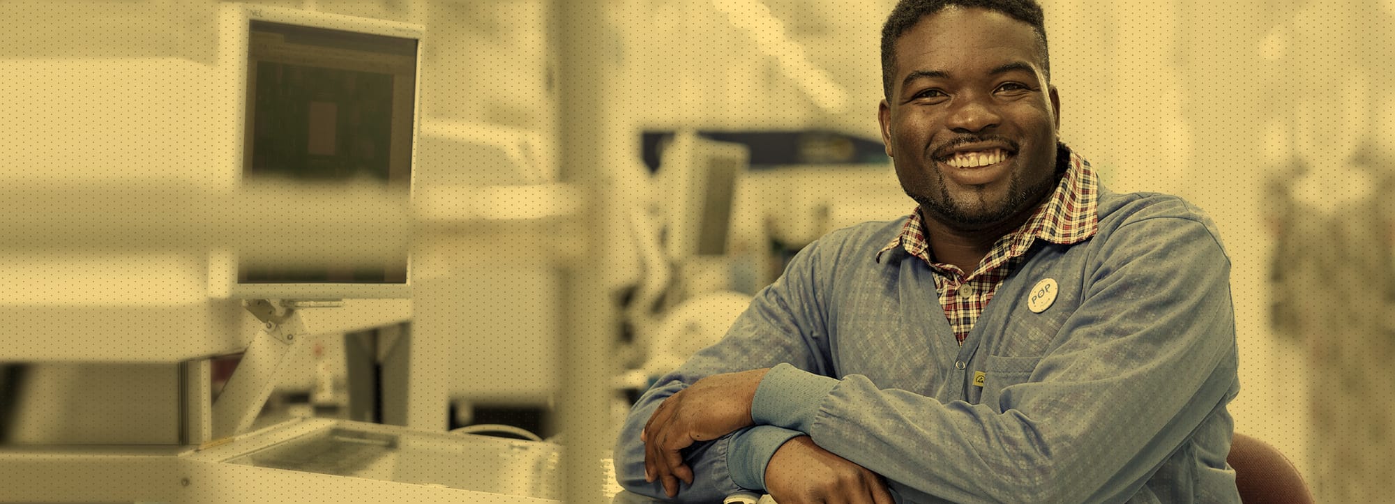 Man sitting by machine smiling at camera