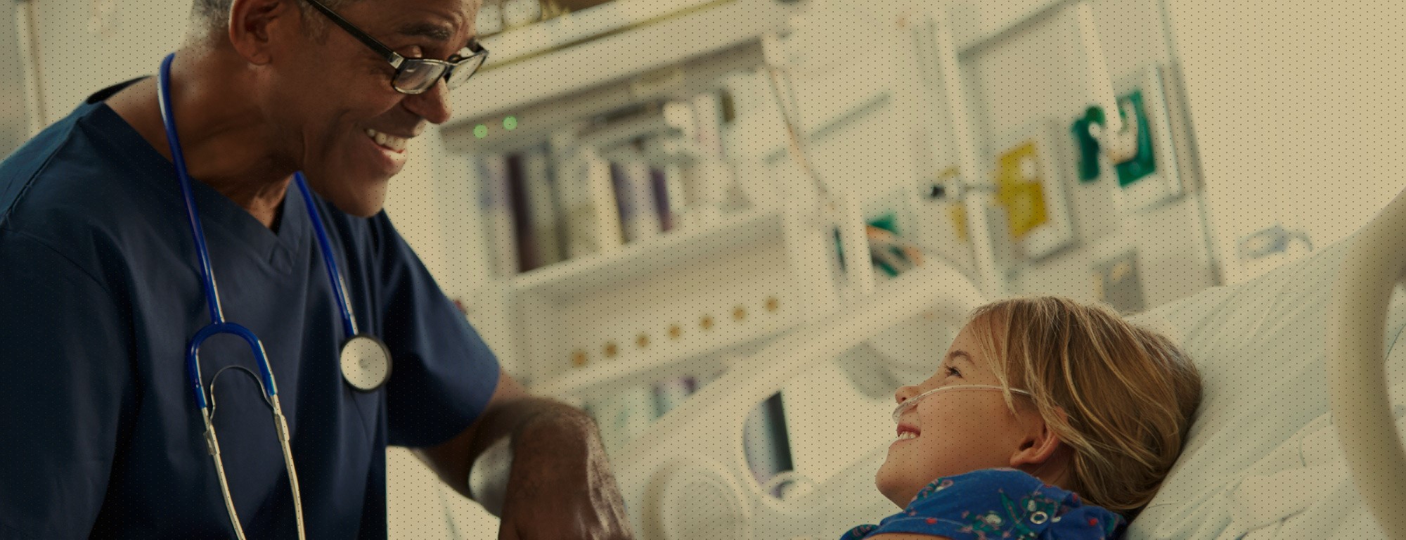 Doctor helping young child in hospital bed