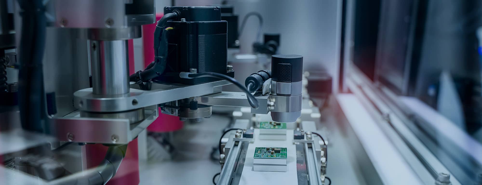 A close-up image of an automated inspection system on a production line, featuring precision cameras analyzing electronic circuit boards.