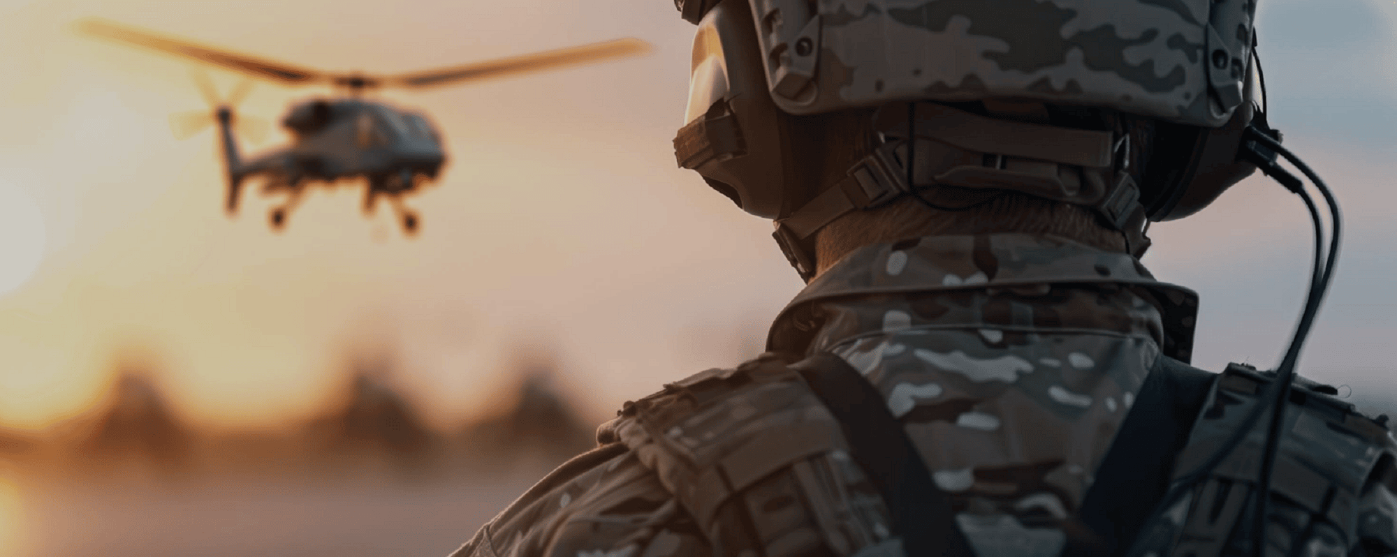 back of a soldiers head looking at a helicopter flying in the background