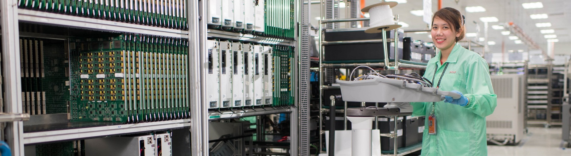 plexus employee carrying a tub of small electronic components