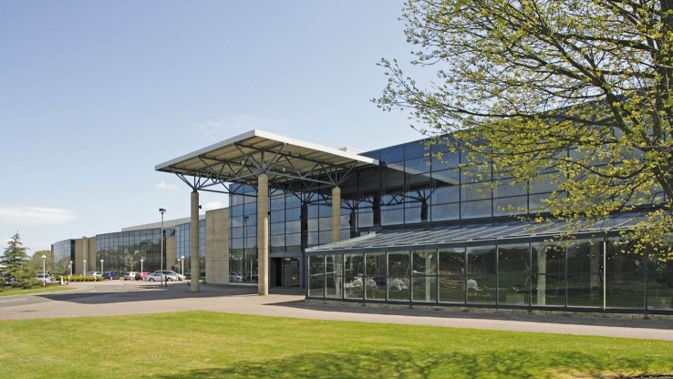A multi-story building with a glass facade, identified as the Plexus Livingston site in the United Kingdom.