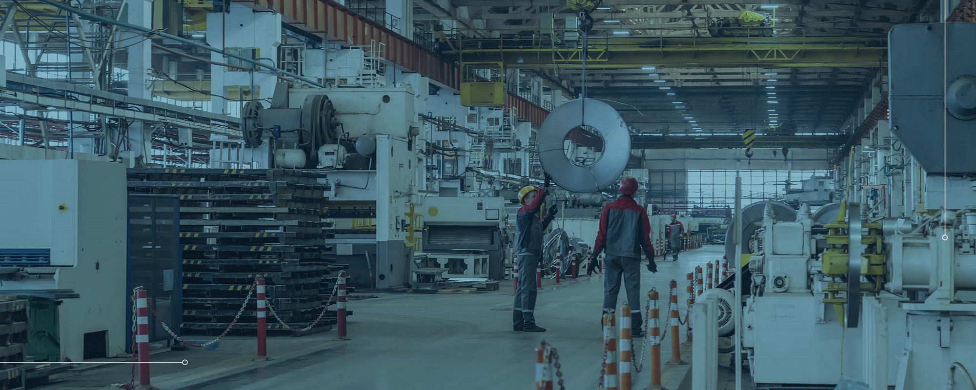 people moving heavy equipment in an industrial manufacturing factory