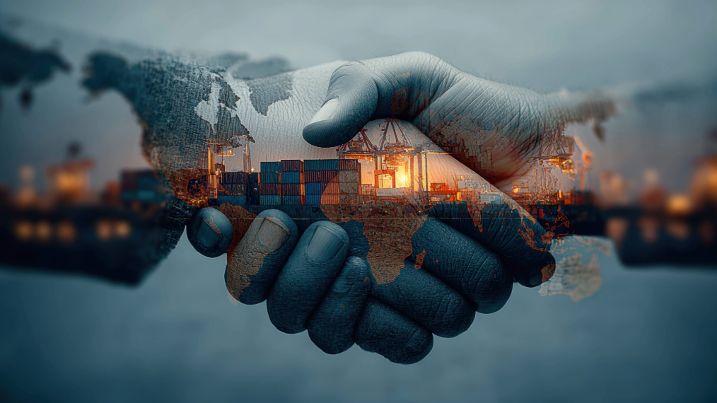Close-up of two hands shaking, with the image overlaid by a world map and a nighttime cargo port with stacked shipping containers.